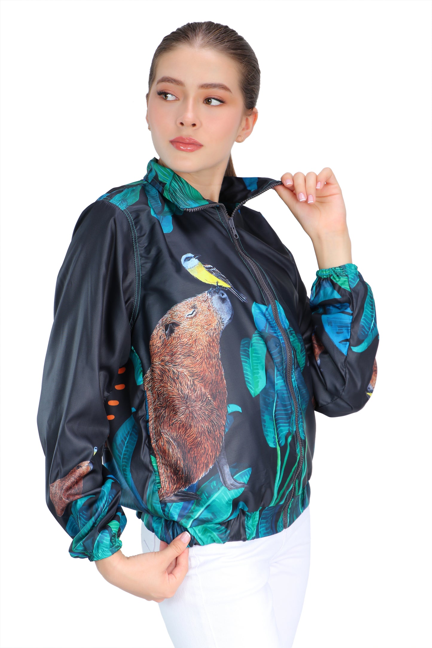 Graphite gray eco-conscious jacket featuring our Capybara friend with a yellow bird on the tip of its nose. Jacket has seven images of the Capybara surrounded by green leaves. The largest Capybara is on the back of the jacket.