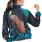 Graphite gray eco-conscious jacket featuring our Capybara friend with a yellow bird on the tip of its nose. Jacket has seven images of the Capybara surrounded by green leaves. The largest Capybara is on the back of the jacket.  Edit alt text